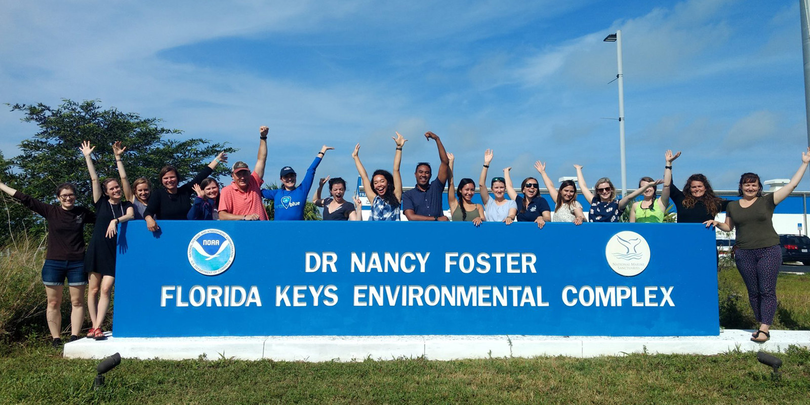 Foster Scholars posing behind the Dr. Nancy Foster Florida Keys Complex sign