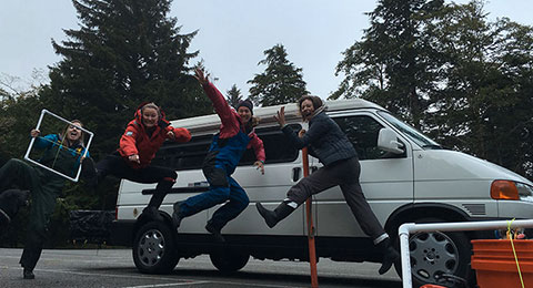 photo of a scholars jumping in front of a white van
