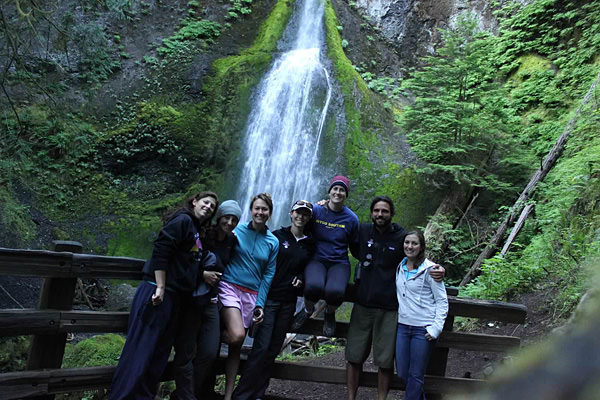 Scholars posing for a picture infront of a waterfall